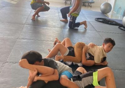 Interior view of a training session at Philippine Top Team, featuring students practicing athletic drills on the academy's professional mats.