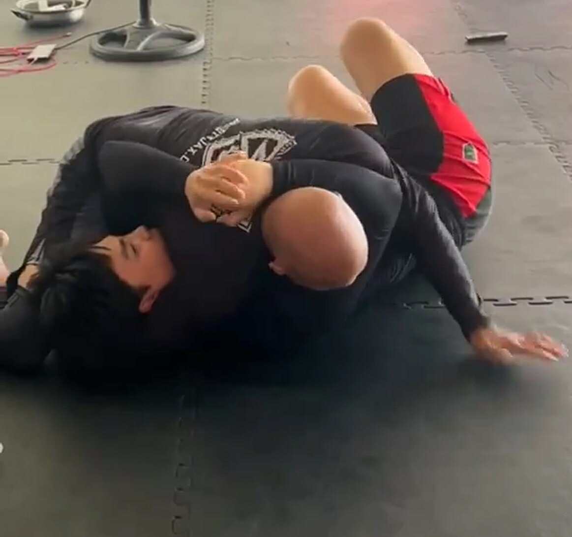 Coach Armand Panganiban demonstrating a pinning technique on a student during an MMA class at Philippine Top Team.