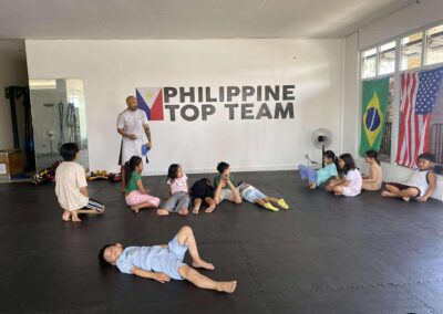 Coach Armand Panganiban leading a Brazilian Jiu-Jitsu session for kids at Philippine Top Team, a martial arts gym in Lapu-Lapu City.