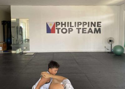 Coach Armand Panganiban providing one-on-one sparring with a young student on the mats at Philippine Top Team.